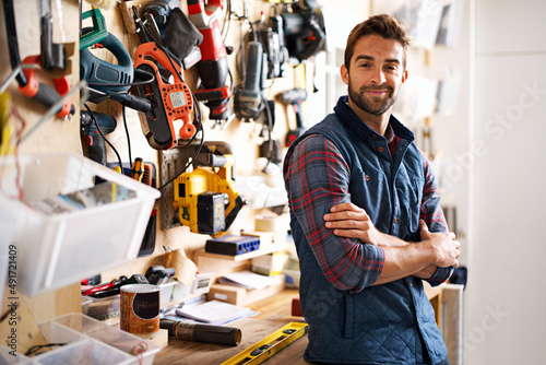 Lets fix it. Portrait of a handsome young handyman standing in front of his work tools. photo