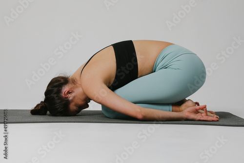 Fototapeta Naklejka Na Ścianę i Meble -  Portrait of young woman practicing yoga asana in class. Isolated.