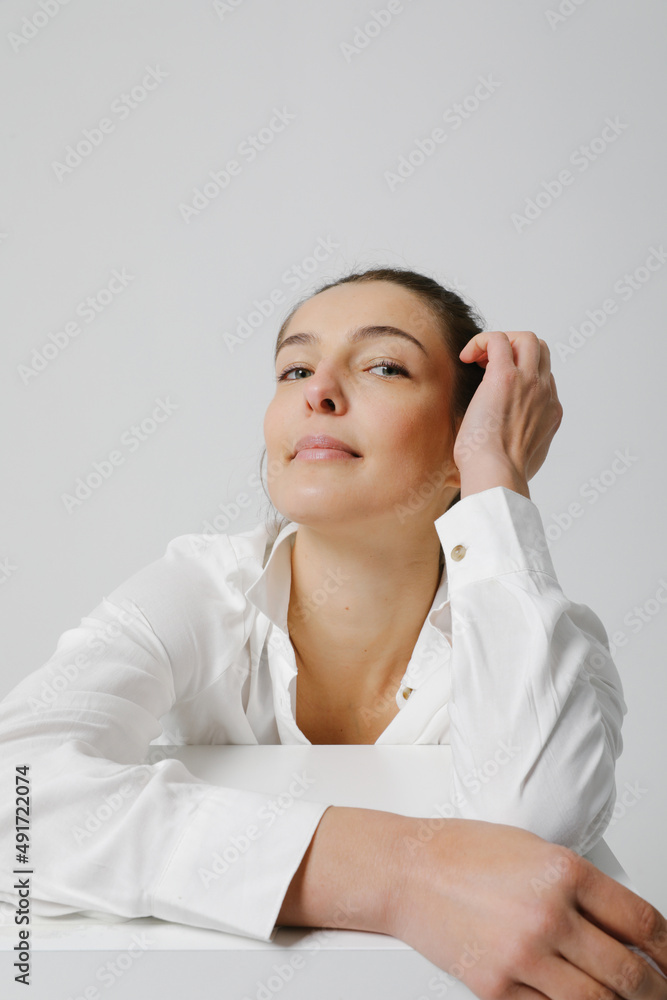 Joyful woman dressed in casual shirt, posing over white wall. Vertical. Joyful woman dressed in casual shirt, posing over white wall. Vertical.