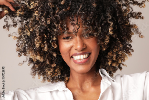 Portrait of joyful woman with afro hair smiling over white background. Isolated. photo