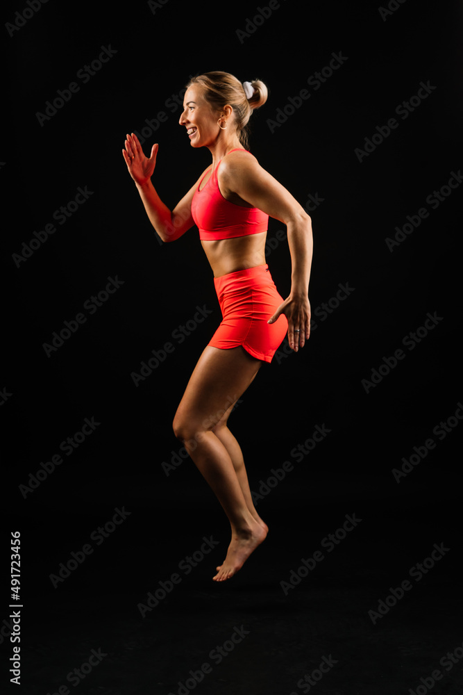 Sporty girl doing exercise with dumbbells, silhouette studio shot over dark and whitebackground