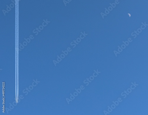 Puste, czyste niebo - na niebie samolot i księżyc, minimalizm, prostota, błękit. Linia i punkt w pustej przestrzeni