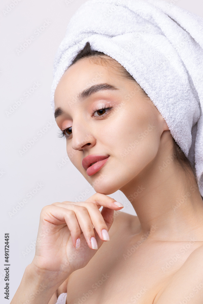 Beautiful girl with thick eyebrows and perfect skin at white background, towel on head, beauty photo. Beautiful girl with thick eyebrows and perfect skin at white background, towel on head, beauty photo.