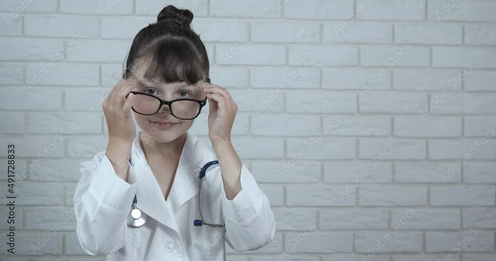 Child make diagnosis. A little girl like a doctor want to examine something in her glasses. A cute little girl plays a doctor. Child make diagnosis. A little girl like a doctor want to examine something in her glasses. A cute little girl plays a doctor.