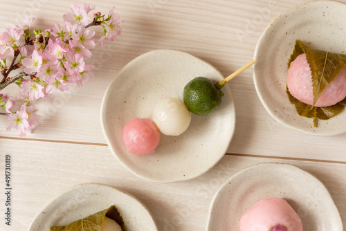 Japanese sweets to eat in spring. Three-color dumplings, sakura mochi, buns. 春に食べる日本の和菓子。3色団子、桜餅、饅頭