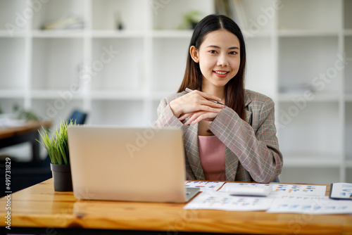 Asian young businesswoman working in the office with laptop computer, doing planning analyzing the financial report, business plan investment, finance analysis concept