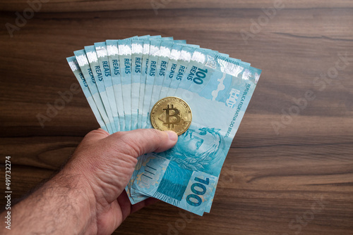 brazil currency bank note hundred reais with bitcoin coin photo