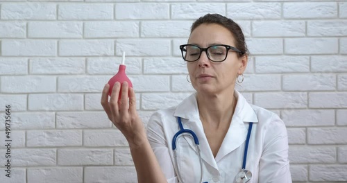 Enema procedure. A doctor hold a pink enema for gastroenterological procedure. photo