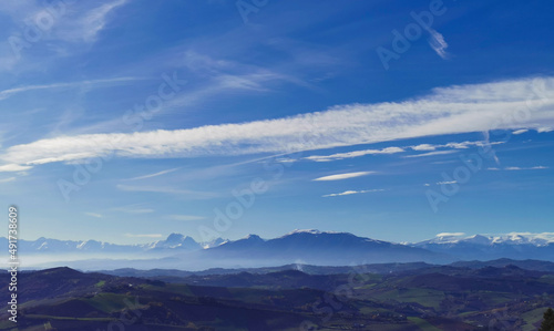 Montagne innevate e vallate nel cielo azzurro in una tersa giornata di sole invernale © GjGj