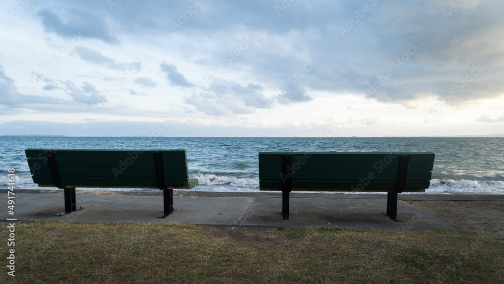 Empty bench facing the sea by the beach, Auckland.