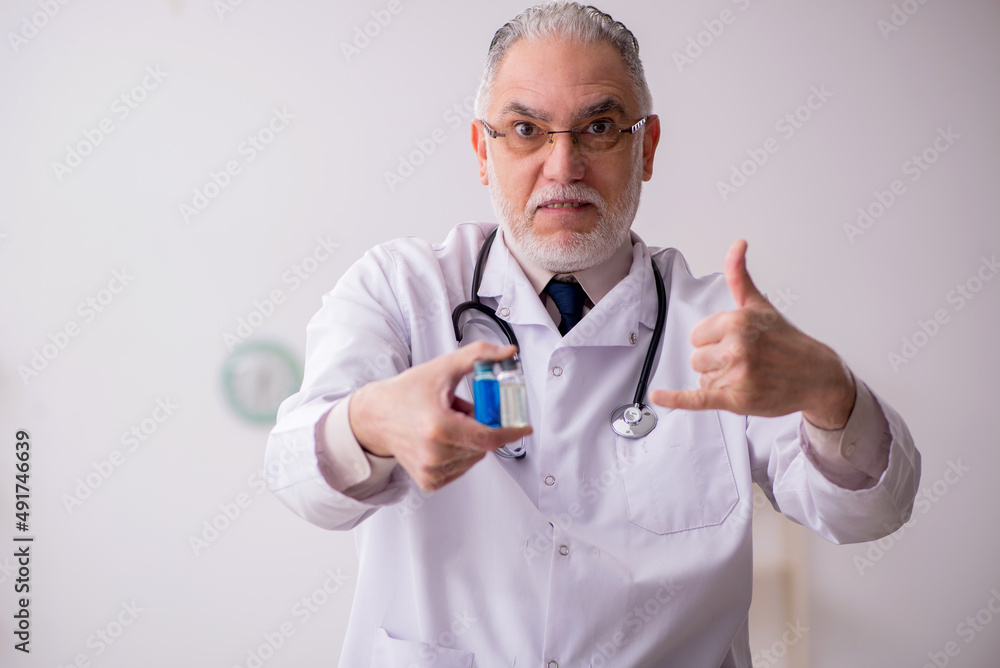 Old male doctor in vaccination concept Old male doctor in vaccination concept