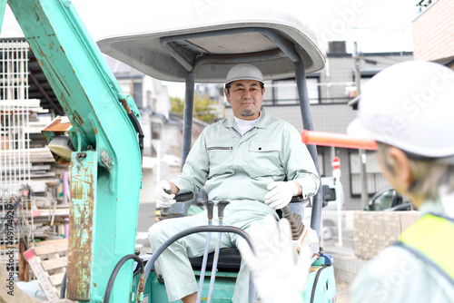 Plakat 工事現場で誘導棒を持つシニアの男性ガードマン（作業員）