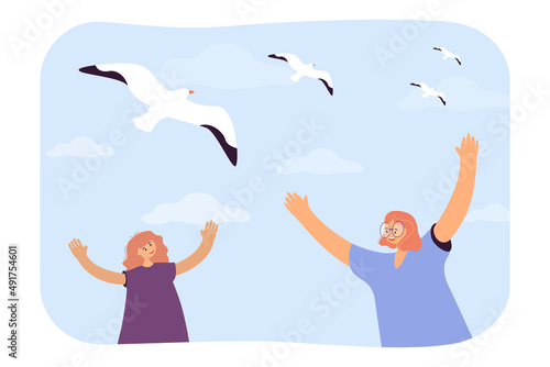Happy girls looking at seagulls in sky flat vector illustration. Smiling friends raising hands, spending summer vacation at sea. Travel, trip concept for banner, website design or landing web page
