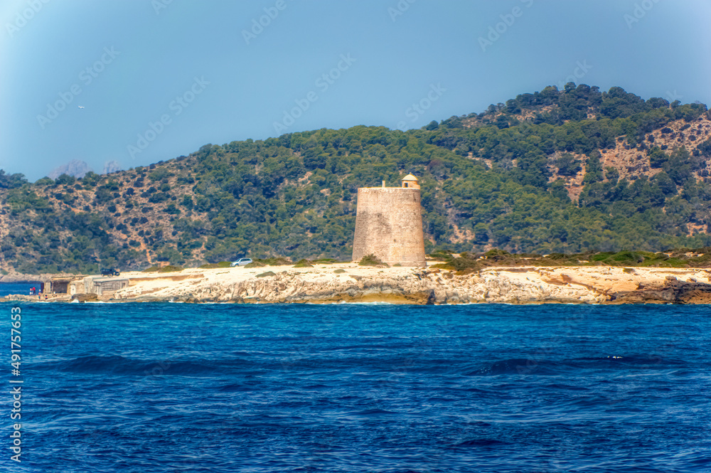  Old medieval watch tower located at lonely and secluded cliff at island of Ibiza, Spain.