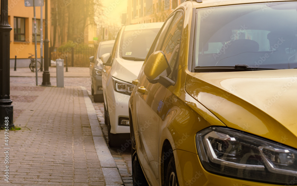Fototapeta premium Cars parked in a row on a city street side