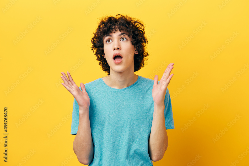 surprised curly guy on a yellow background posing surprised curly guy on a yellow background posing