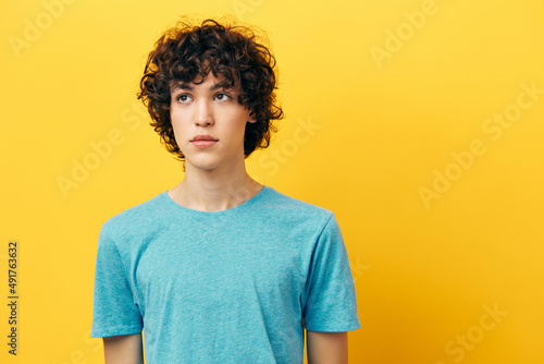 cute guy with curly hair posing yellow background fashion