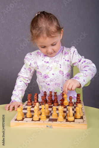 a little girl is playing chess