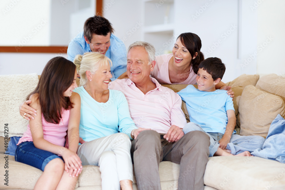 Enjoying grannys joke together. A loving family laughing on a lounge sofa together. Enjoying grannys joke together. A loving family laughing on a lounge sofa together.