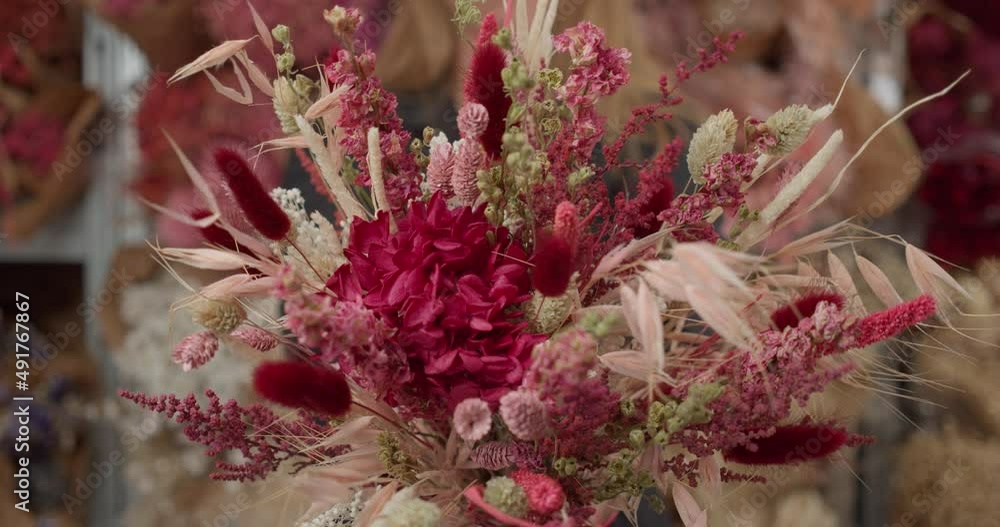 Woman offering colorful bouquet of natural dried flowers. Walking backwards Woman offering colorful bouquet of natural dried flowers. Walking backwards