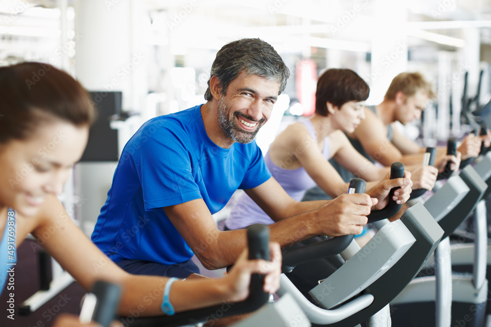 Im almost done for the day. Cropped shot of a row of people working out on the exercise bikes at the gym. Im almost done for the day. Cropped shot of a row of people working out on the exercise bikes at the gym.
