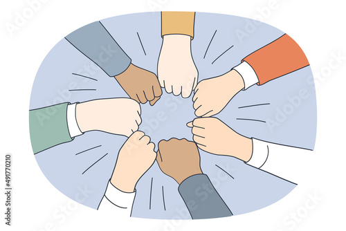 Collaboration teamwork and unity concept. Top view of diverse multi racial group of people pulling fists together in circle meaning togetherness and tolerance vector illustration  photo