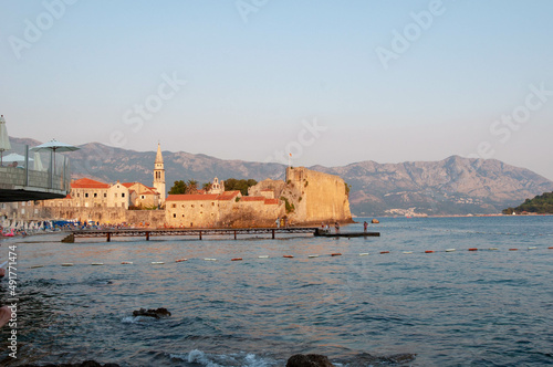 a view on the old fortress and old town from the sea shore of the marina in the sunrise