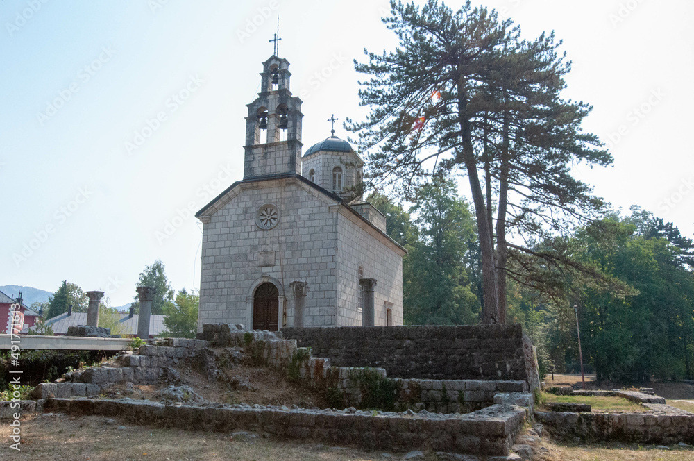 a church near a big pine tree in the mountains of Montenegro