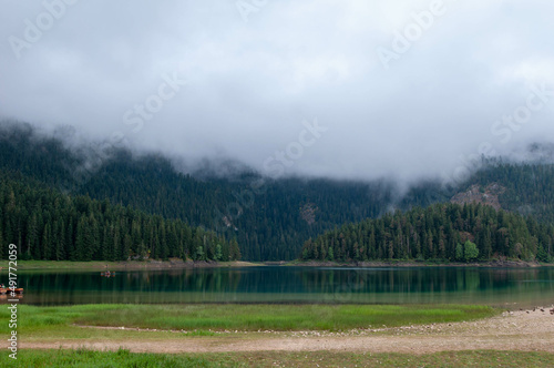 a foggy landscape of a mountain lake surrounded by a forest