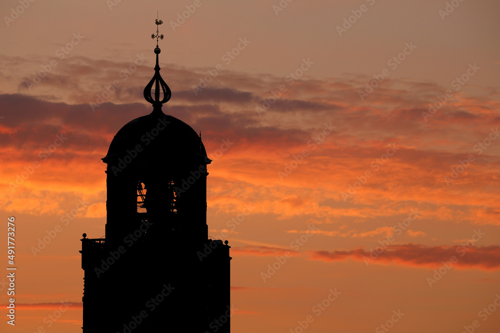 The tower of the Great Church in Deventer, the Netherlands, against a dramatic sky at sunset
