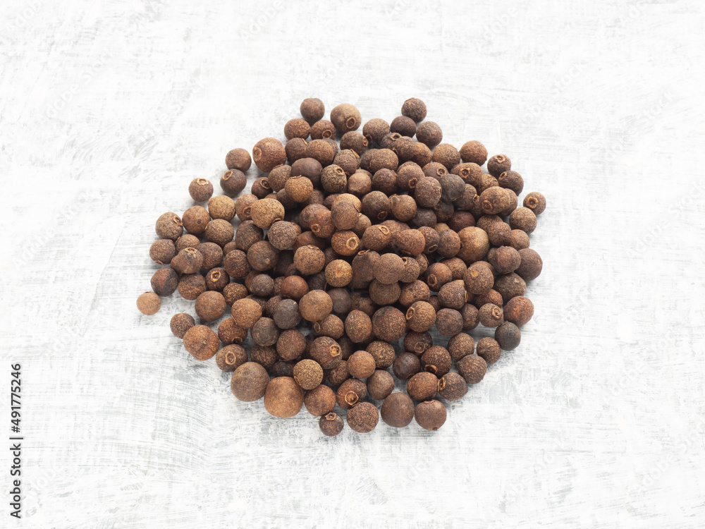 Spice Allspice in bunch on white concrete background. Macro. Healthy diet concept Spice Allspice in bunch on white concrete background. Macro. Healthy diet concept