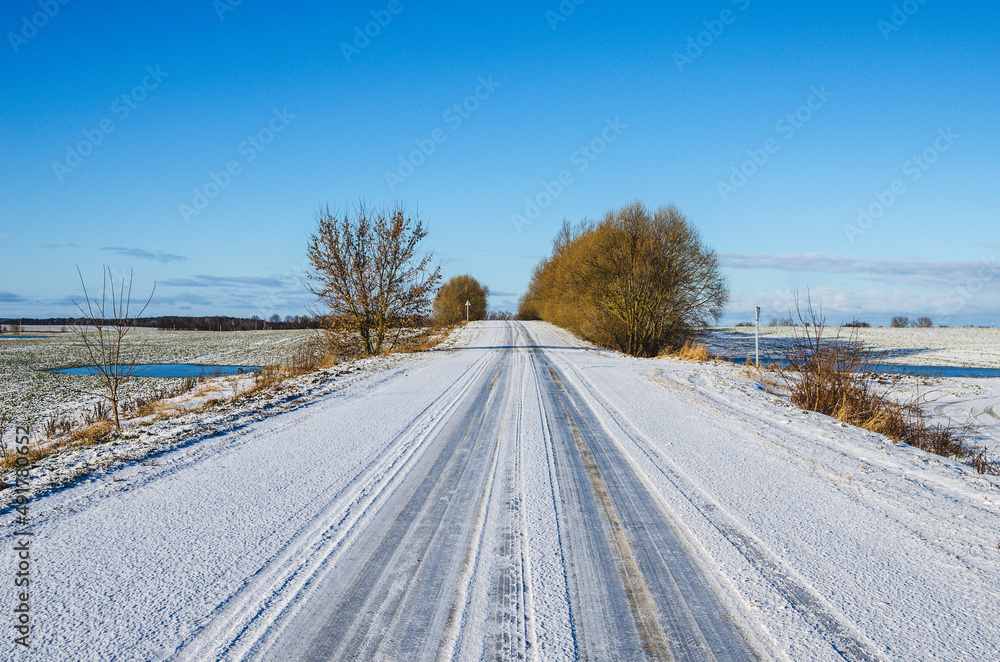 Obraz premium Winter landscape in the countryside. Road going into the distance