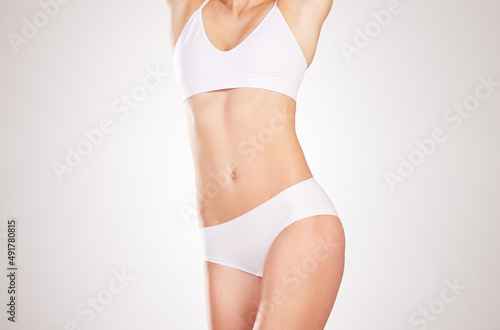 Beauty on display. Studio shot of an unrecognizable young woman posing in her underwear against a grey background.