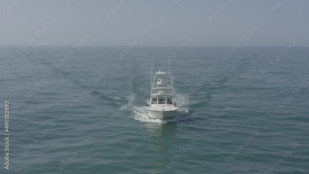 Small White Fishing boat sailing across calm smooth Sea, Aerial view. Small White Fishing boat sailing across calm smooth Sea, Aerial view.
