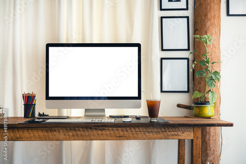 Computer on a desk at home with white curtains
