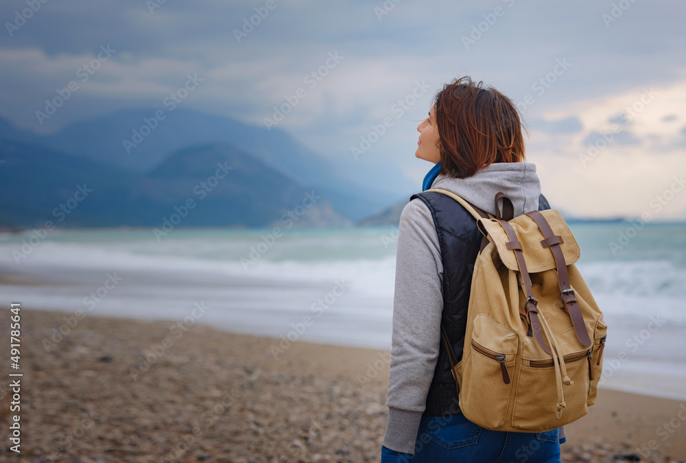 antalya, turkey, winter walk by the mediterranean sea. Attractive young woman standing on a windy cold beach. antalya, turkey, winter walk by the mediterranean sea. Attractive young woman standing on a windy cold beach.