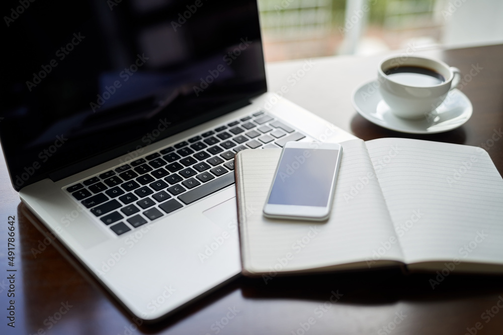 Take a seat and lets get started with success. High angle shot of a laptop, cellphone and notebook on a table. Take a seat and lets get started with success. High angle shot of a laptop, cellphone and notebook on a table.