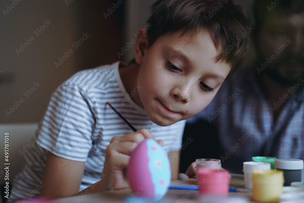 Cute little boy colouring eggs for easter Cute little boy colouring eggs for easter