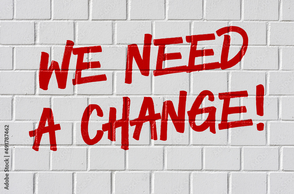 Graffiti on a brick wall - We need a change Graffiti on a brick wall - We need a change
