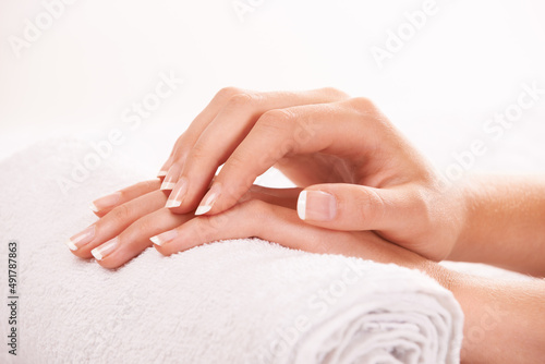 Feeling her smooth skin. Cropped shot of a womans hands resting on a towel.