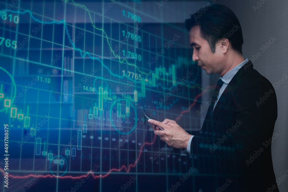 Double exposure business man wearing suite looking at diagram graph investment in business have detail smart phone on hand with diagram graph investment background. Double exposure business man wearing suite looking at diagram graph investment in business have detail smart phone on hand with diagram graph investment background.