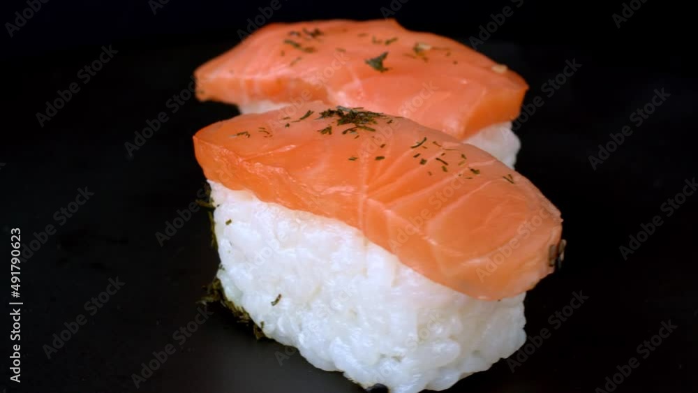 Close-up detail view of sushi. Sushi nigiri with salmon fish food on black background. Table spin. Close-up detail view of sushi. Sushi nigiri with salmon fish food on black background. Table spin.