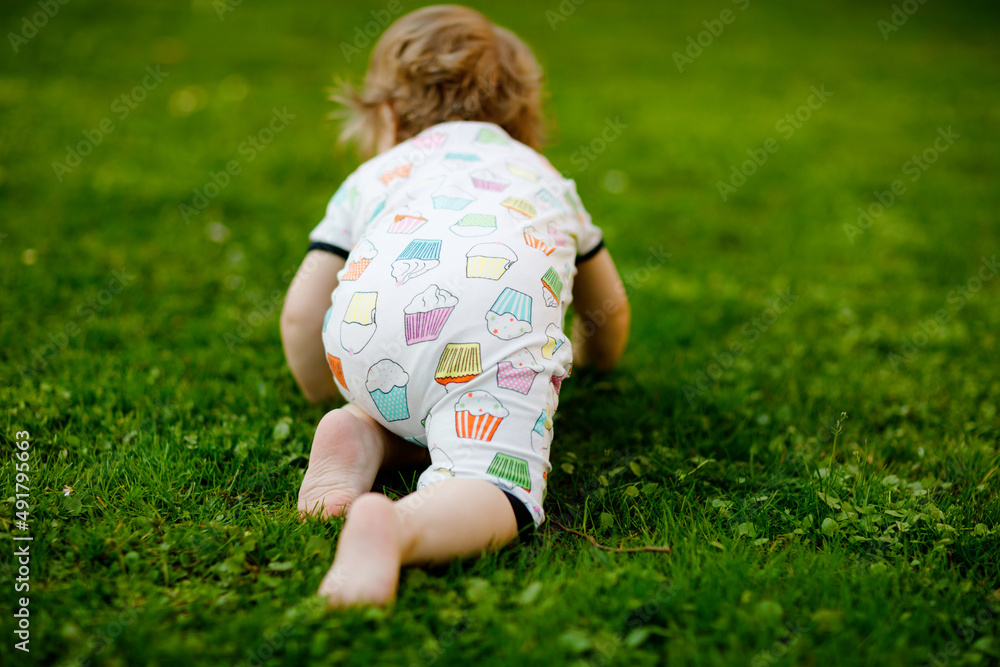 Cute adorable baby girl crawl and make first steps outdoors. Healthy happy toddler child learning walking. Lovely girl enjoy spring garden explore world. Cute adorable baby girl crawl and make first steps outdoors. Healthy happy toddler child learning walking. Lovely girl enjoy spring garden explore world.