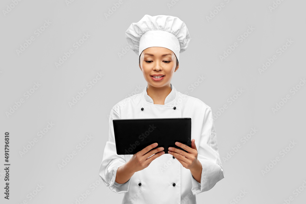 cooking, culinary and people concept - happy smiling female chef with tablet pc computer over grey background cooking, culinary and people concept - happy smiling female chef with tablet pc computer over grey background