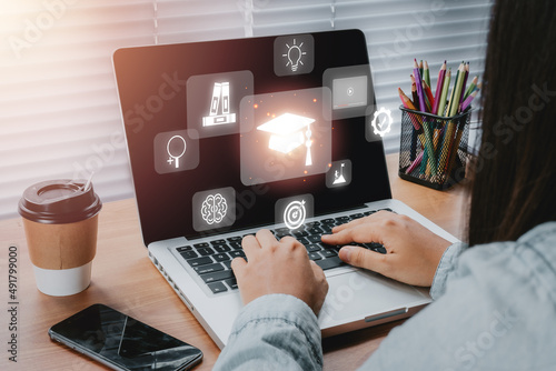 Принти на полотні Online education training, Person hand using laptop computer with VR screen education icon background, webinar online