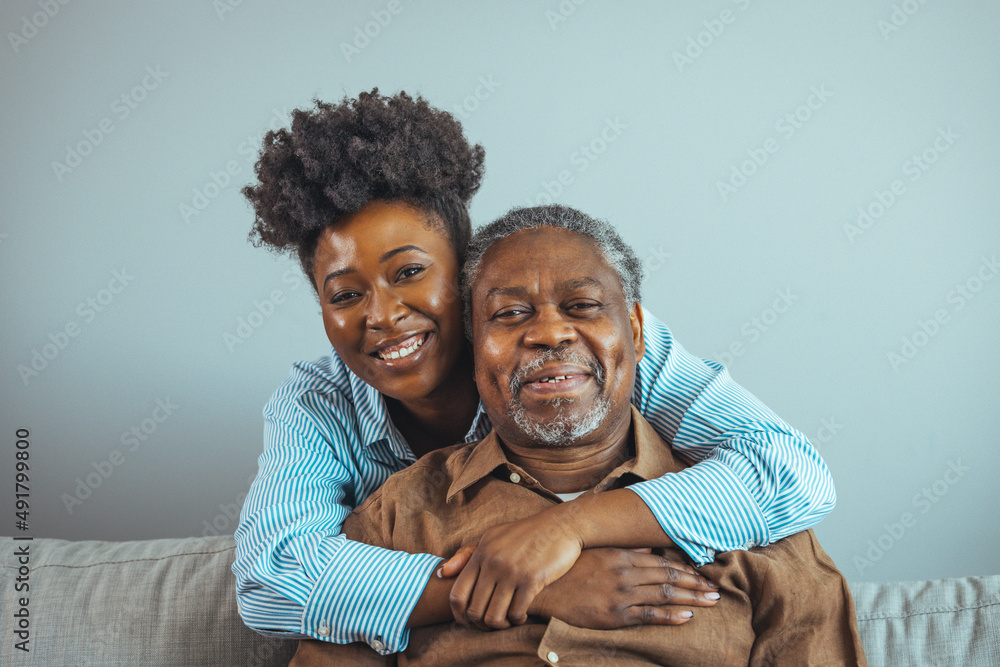 Close up faces of elderly 80s grandfather adult 30s granddaughter. Teenager girl sitting on window with father. Beautiful African American woman with her father as they both smile
