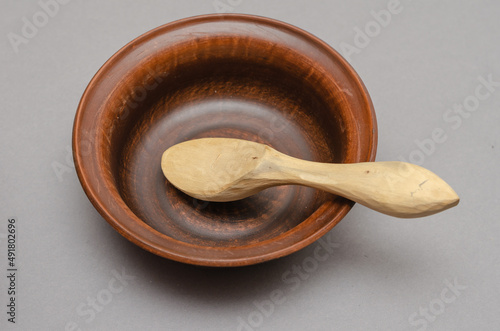 Photography Brown earthenware bowl and buckshot against a gray background.
