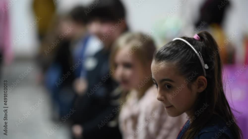 Young girl playing in game room with all her friends, focus on her Young girl playing in game room with all her friends, focus on her