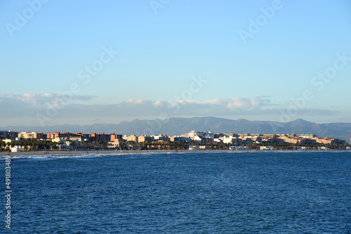 View on coastline and beach from La Marina de Valencia on the sea to the Las Arenas beach, Playa de las Arenas, Platja del Cabanyal and Playa de la Malvarrosa. Waves at sea on blue sky background. © MaxSafaniuk