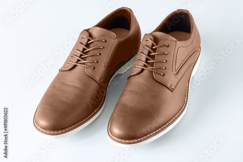 Casual male leather bown shoes on gray background